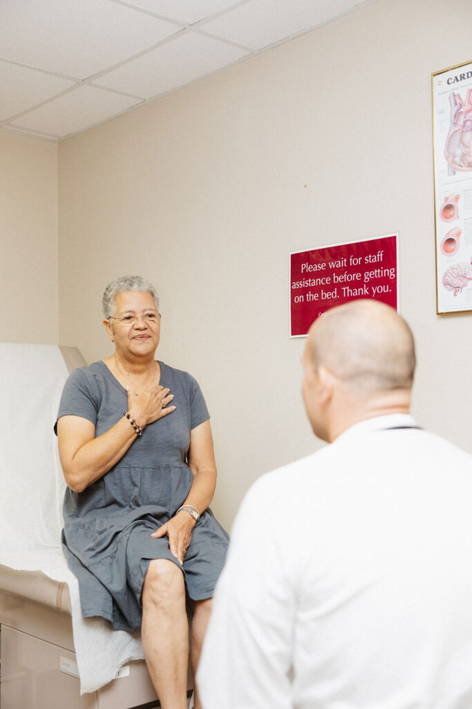 A patient in a gray dress looks relieved after getting good news from a CIS cardiologist