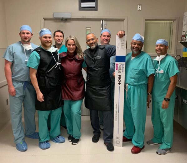 A group of CIS staff members pose with a box containing the Evolut Pro valve replacement device