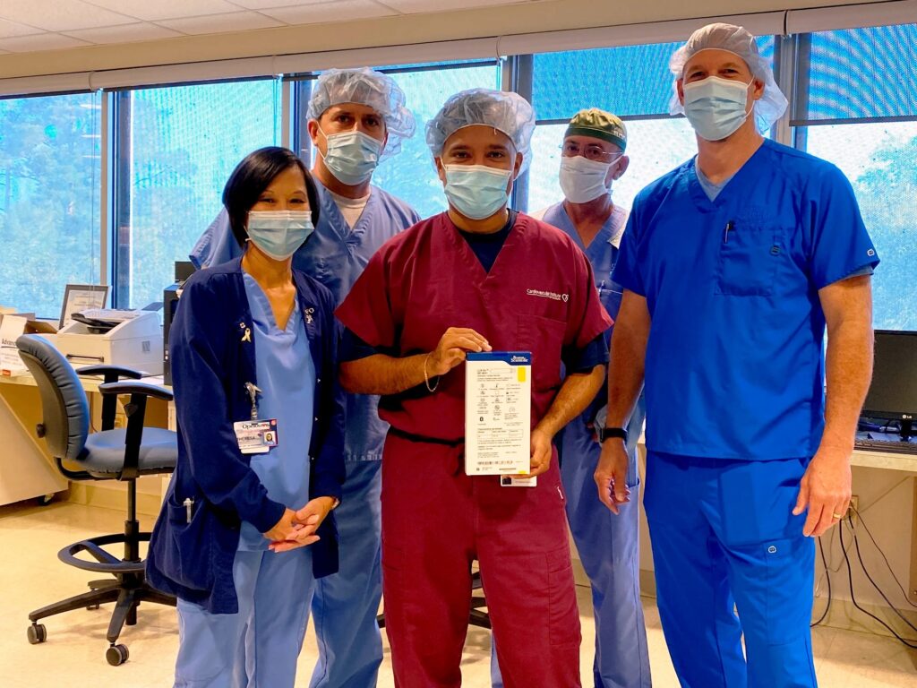 A group of CIS staff members poses with a box containing the LUX-Dx™ Insertable Cardiac Monitor (ICM) System