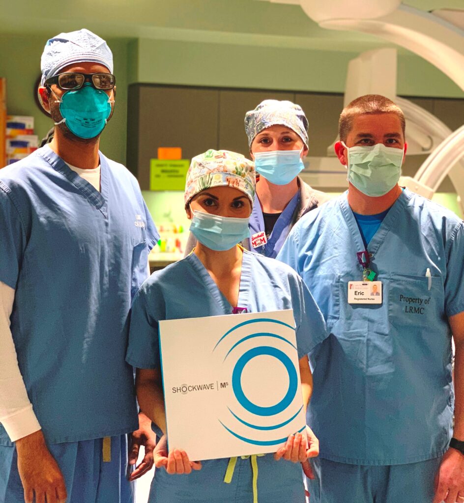 A group of CIS staff members in scrubs poses with a box containing the Shockwave lithotripsy balloon