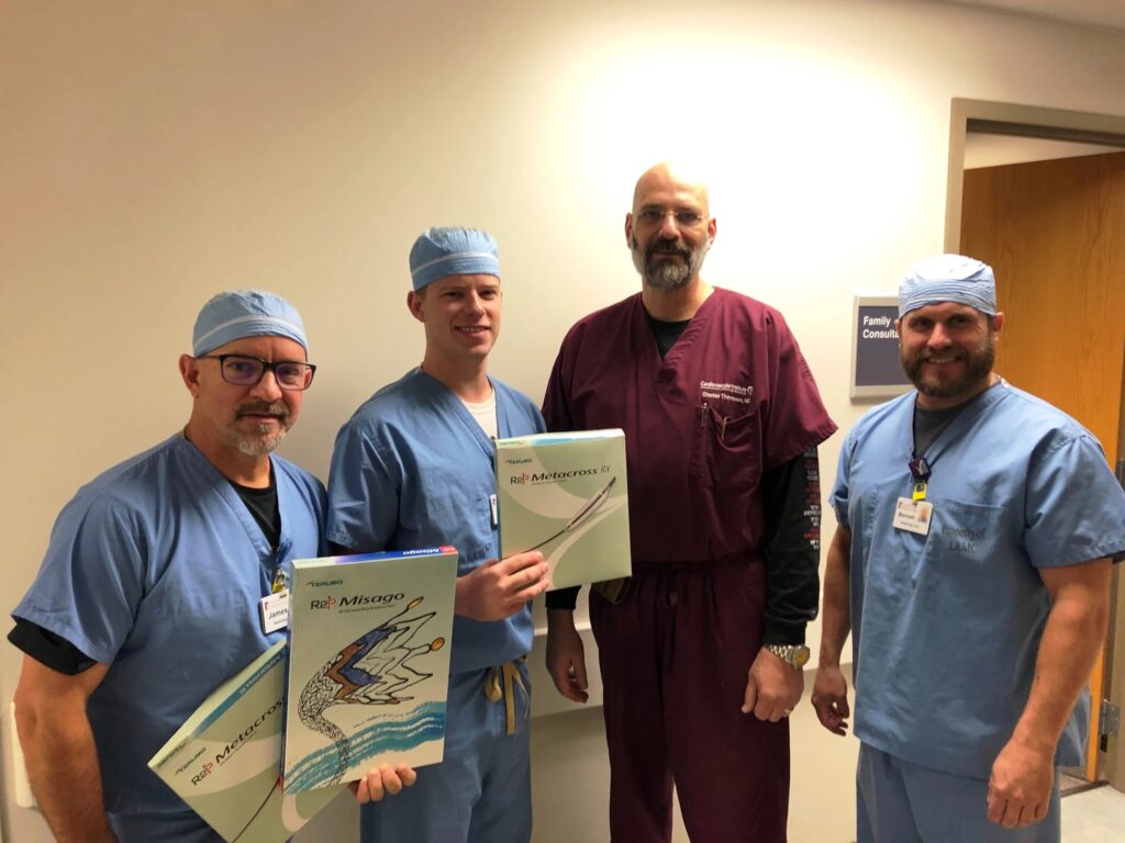 A group of CIS staff members poses with boxes containing components of the  R2P™ MISAGO® RX self-expanding stent