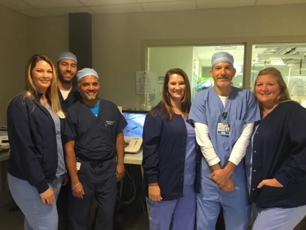 A group of CIS staff in scrubs posing for a picture, looking happy