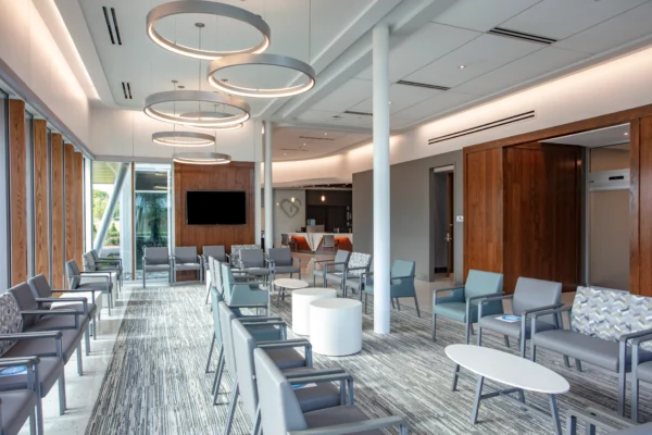 Modern cardiology office waiting area with stylish seating, wooden accents, and circular overhead lighting.