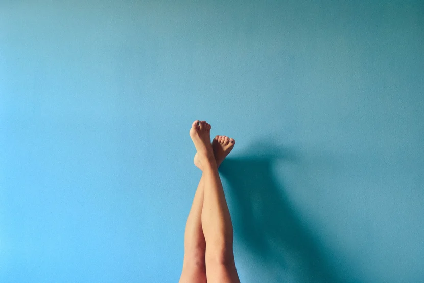 Bare feet casually raised against a serene blue backdrop, casting a lazy afternoon shadow, reminiscent of the calm often sought after cardiovascular treatments from the Cardiovascular Institute of the South.