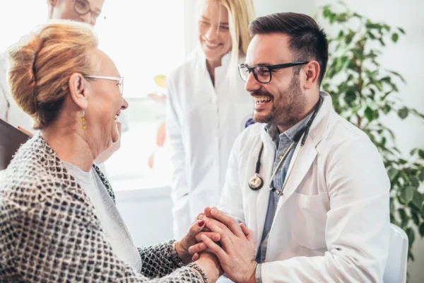 A caring cardiologist reassuring a happy elderly patient with a gentle hand hold during a medical consultation at the Cardiovascular Institute of the South.