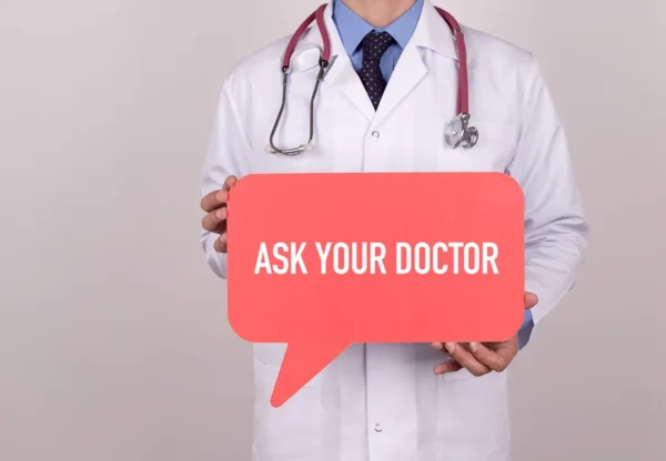 A healthcare professional holding a speech bubble sign that says "ask your Heart Doctor", promoting medical consultation and advice-seeking at the Cardiovascular Institute of the South.