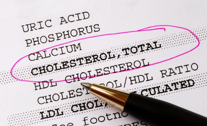 A close-up of a blood test report highlighting cholesterol levels, crucial for cardiology, with a pen resting on the paper.