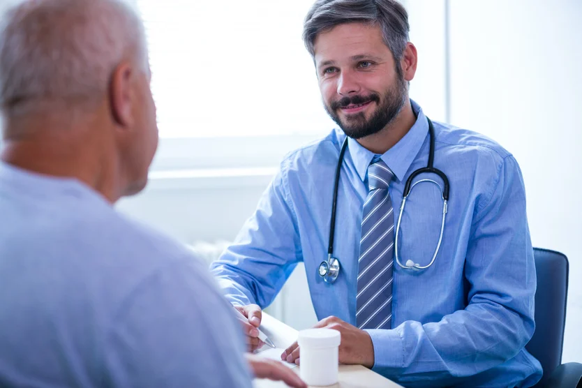 A caring healthcare professional engaged in a conversation with an elderly patient about venous disease during a medical consultation at the Cardiovascular Institute of the South.