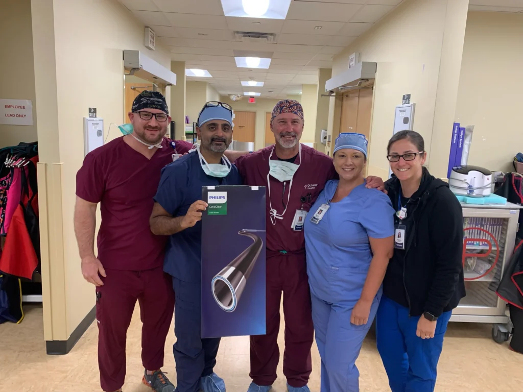 A group of happy-looking CIS staff poses with a box containing the new Philips CavaClear