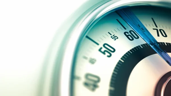 Close-up of a bathroom scale dial showing the needle pointing to a specific weight, an essential tool for monitoring heart health.