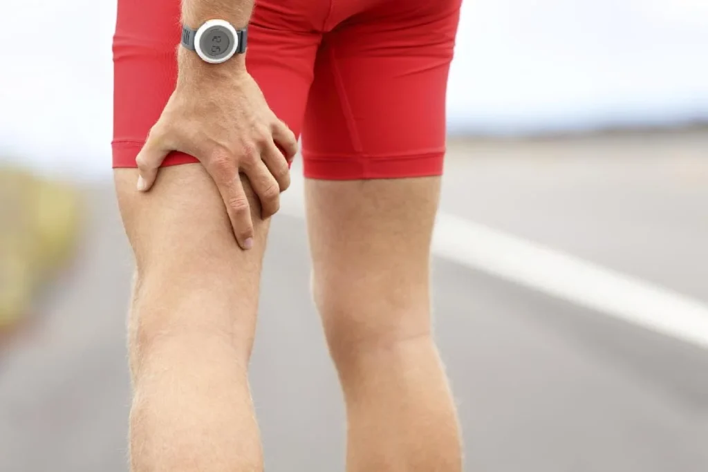 A runner experiencing knee pain during a workout, possibly indicating a sports injury, strain, or venous disease.